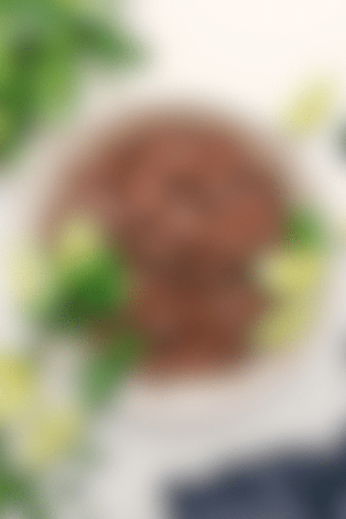 Copycat Chipotle Beef Barbacoa Chipotle beef barbacoa in a bowl with fresh cilantro and lime wedges on the side.