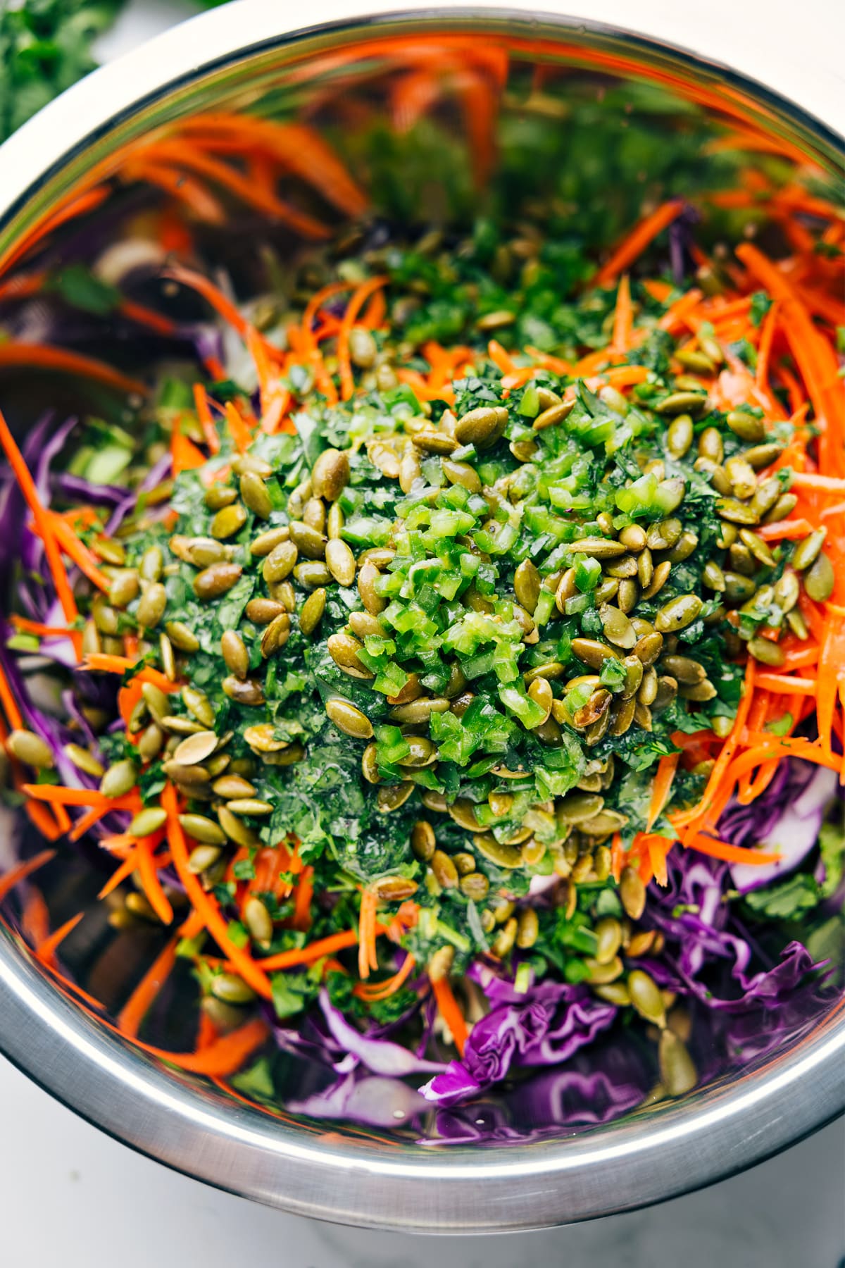 How To Make This Healthy Slaw Healthy Slaw ingredients in a large bowl with the dressing poured over the top, ready to be tossed together.