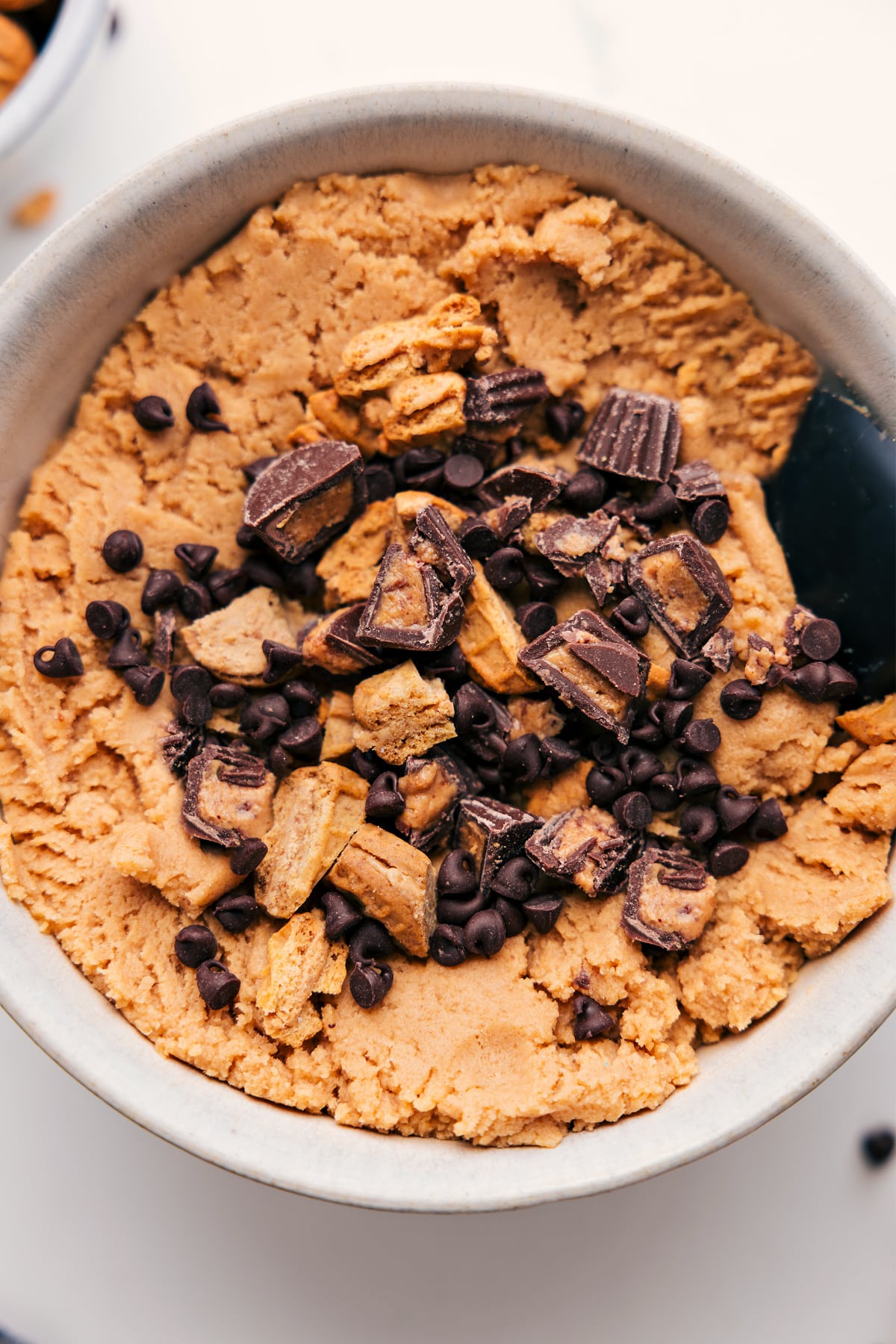 Peanut Butter Edible Cookie Dough in a bowl topped with peanut butter cups and Nutter Butters.