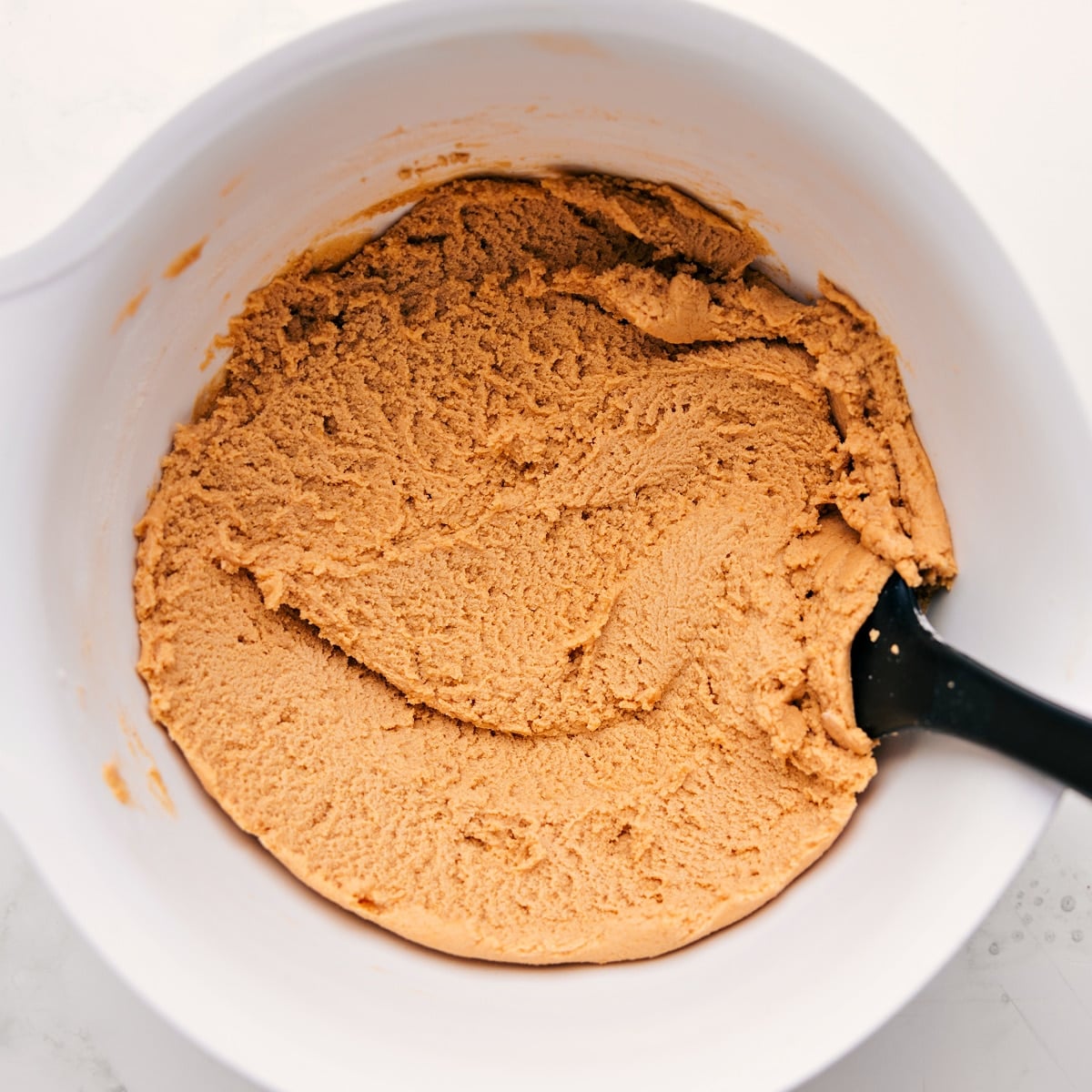 The safe to eat dough in a bowl ready to be enjoyed.