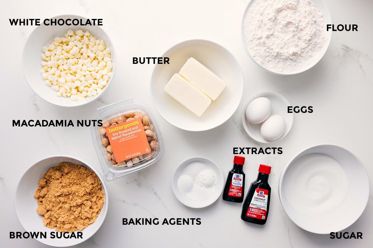Ingredients In This Recipe For Macadamia Nut White Chocolate Cookies All the ingredients in this recipe prepped out for easy assembly including the white chocolate, macadamia nuts, brown sugar, butter, flour, eggs, extracts, sugar, and baking agents.