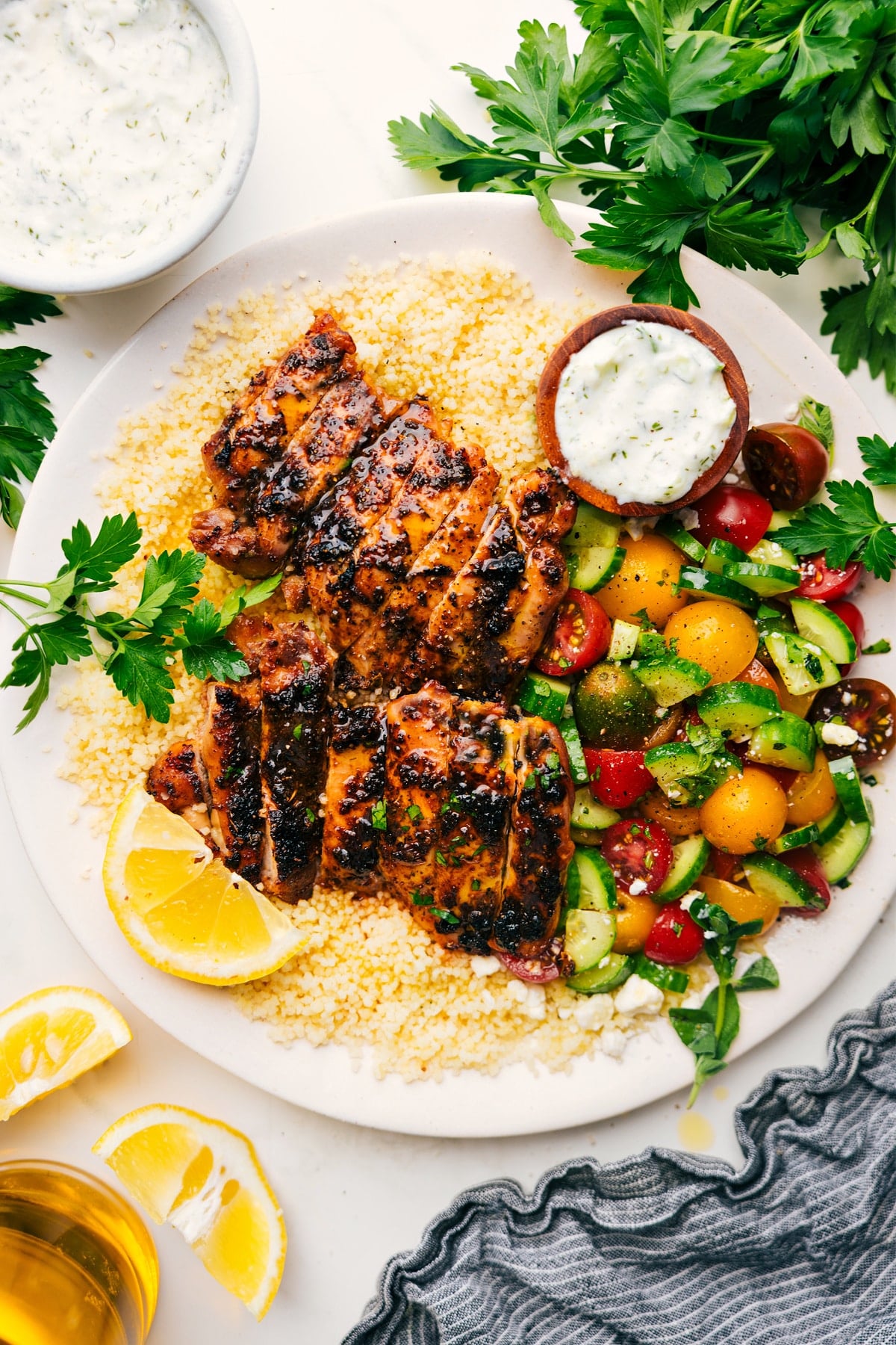 Chicken Gyro Bowls with couscous, tomato cucumber salad, and tzatziki on the side.