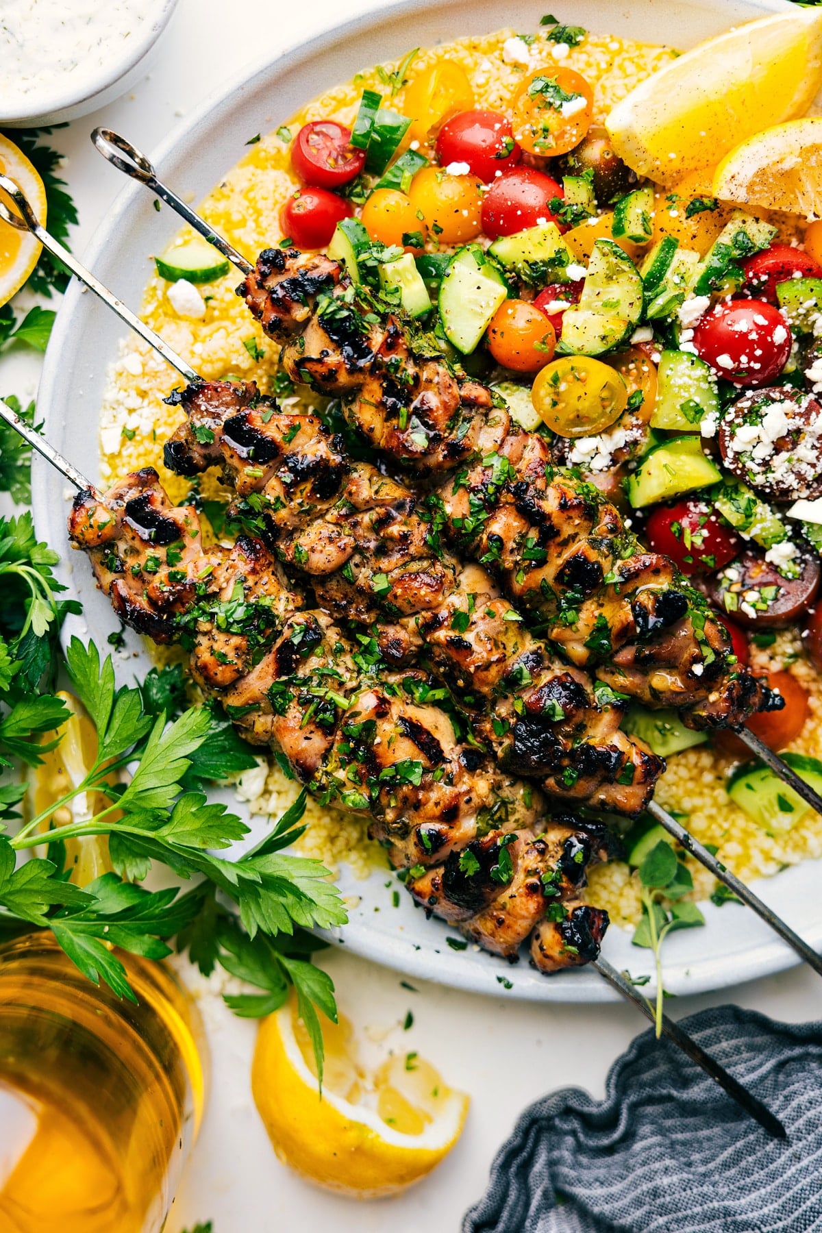 Chicken Souvlaki Over Couscous Chicken Souvlaki served over couscous with a cucumber tomato salad on the side.