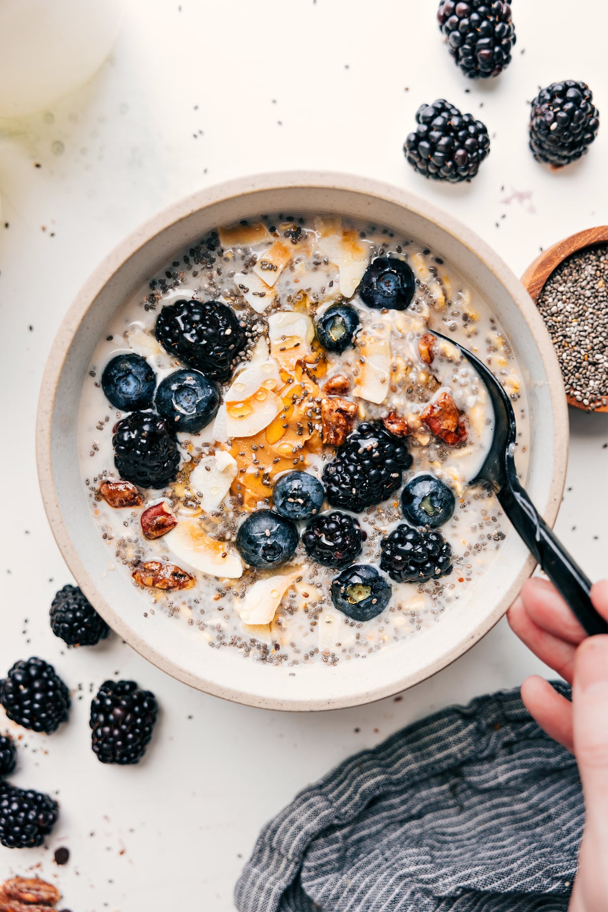 Protein overnight oats topped with coconut, fresh berries, and a drizzle of honey.