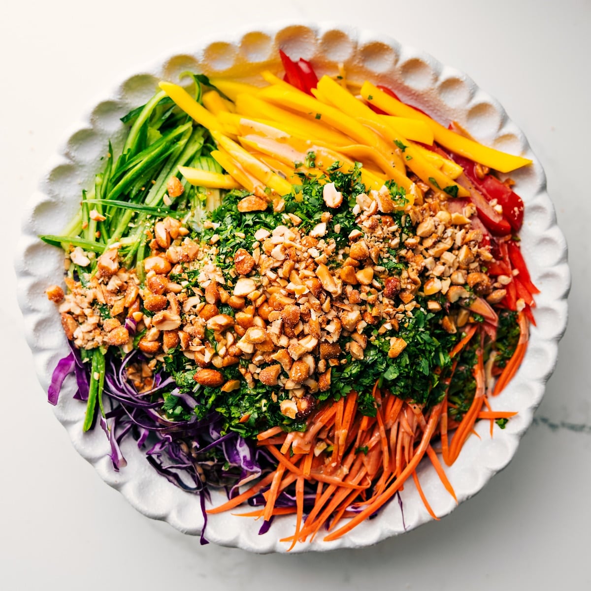 Adding all the ingredients for this spring roll salad into a large bowl to dress and toss together.