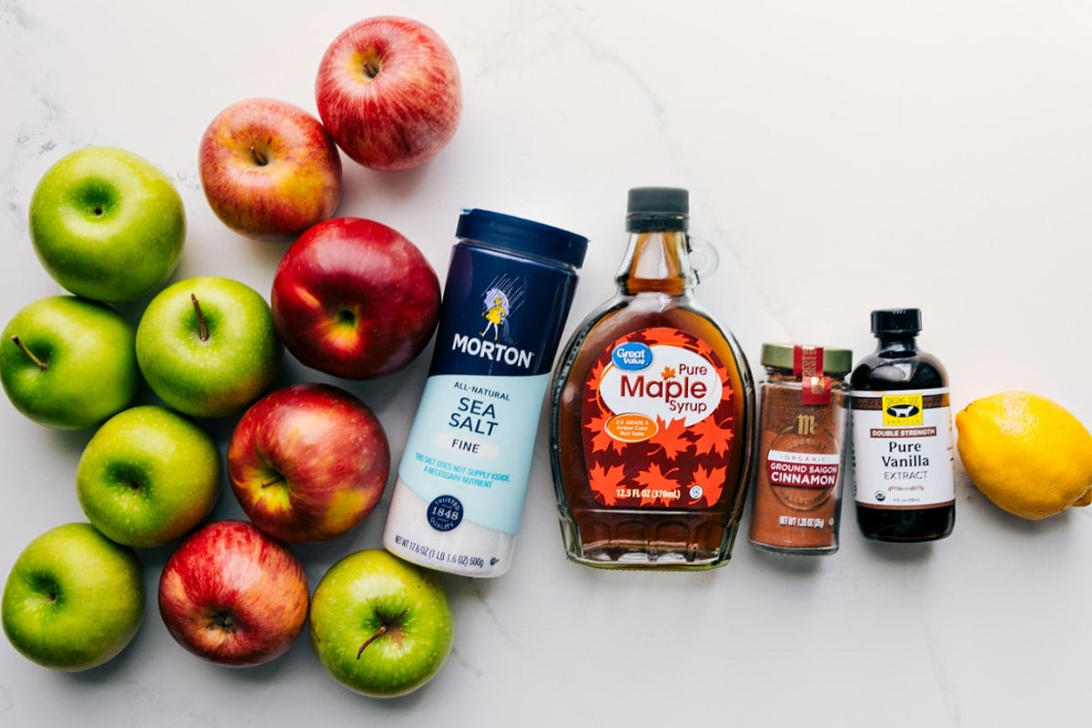 All the ingredients in this recipe prepped out for easy assembly including the apples, salt, maple syrup, cinnamon, vanilla, and lemon.