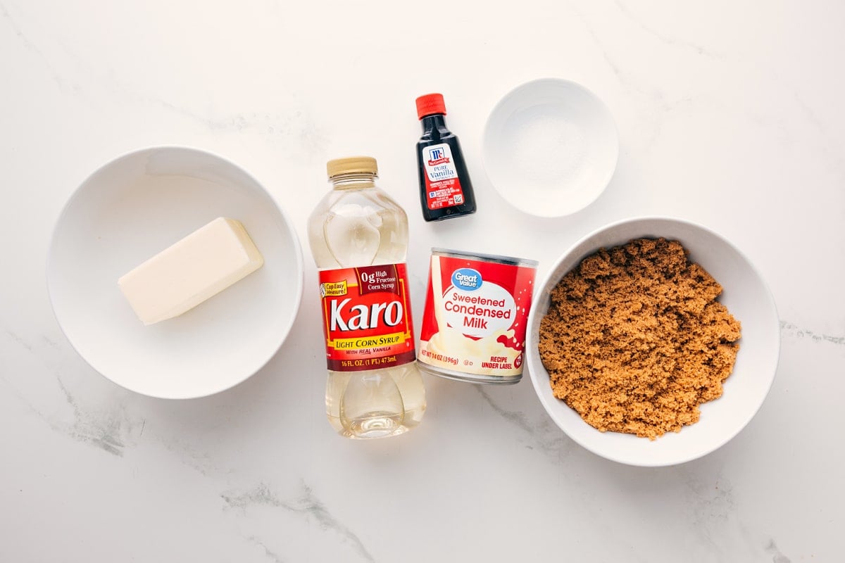 All the ingredients in this recipe prepped out for easy assembly including the butter, corn syrup, sweetened condensed milk, brown sugar, vanilla, and salt.