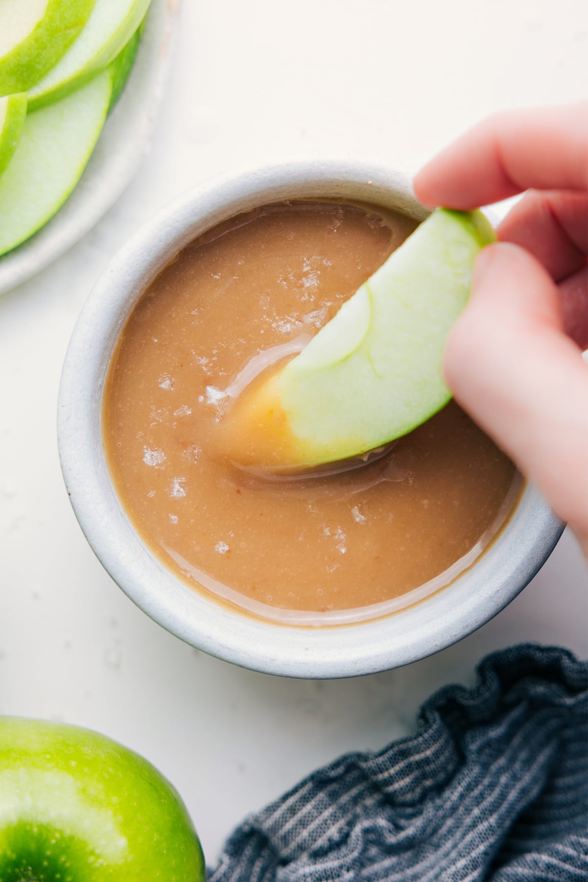 Easy Caramel Sauce Recipe with an apple dipped into it.