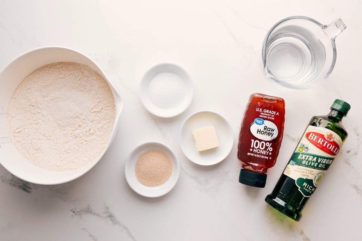 Activating The Yeast For Focaccia All the ingredients in this recipe prepped out for easy assembly including flour, yeast, honey, butter, salt, oil, and water.