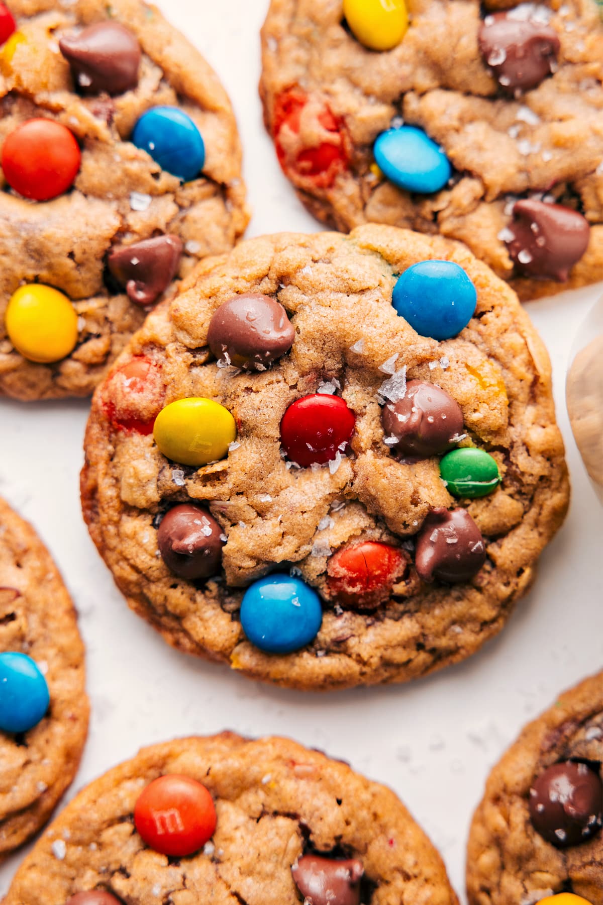 Freshly baked Monster Cookies topped with a sprinkle of flaky sea salt.