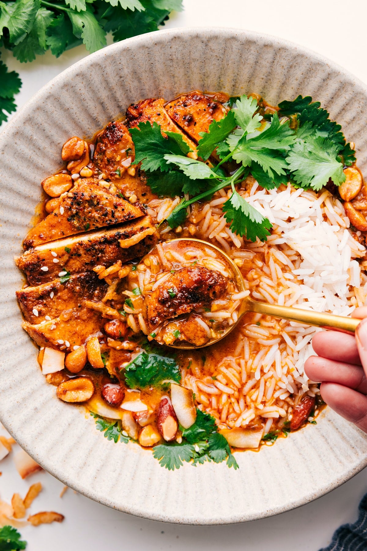 Yellow curry broth bowl with a spoon lifting a bite from the bowl.